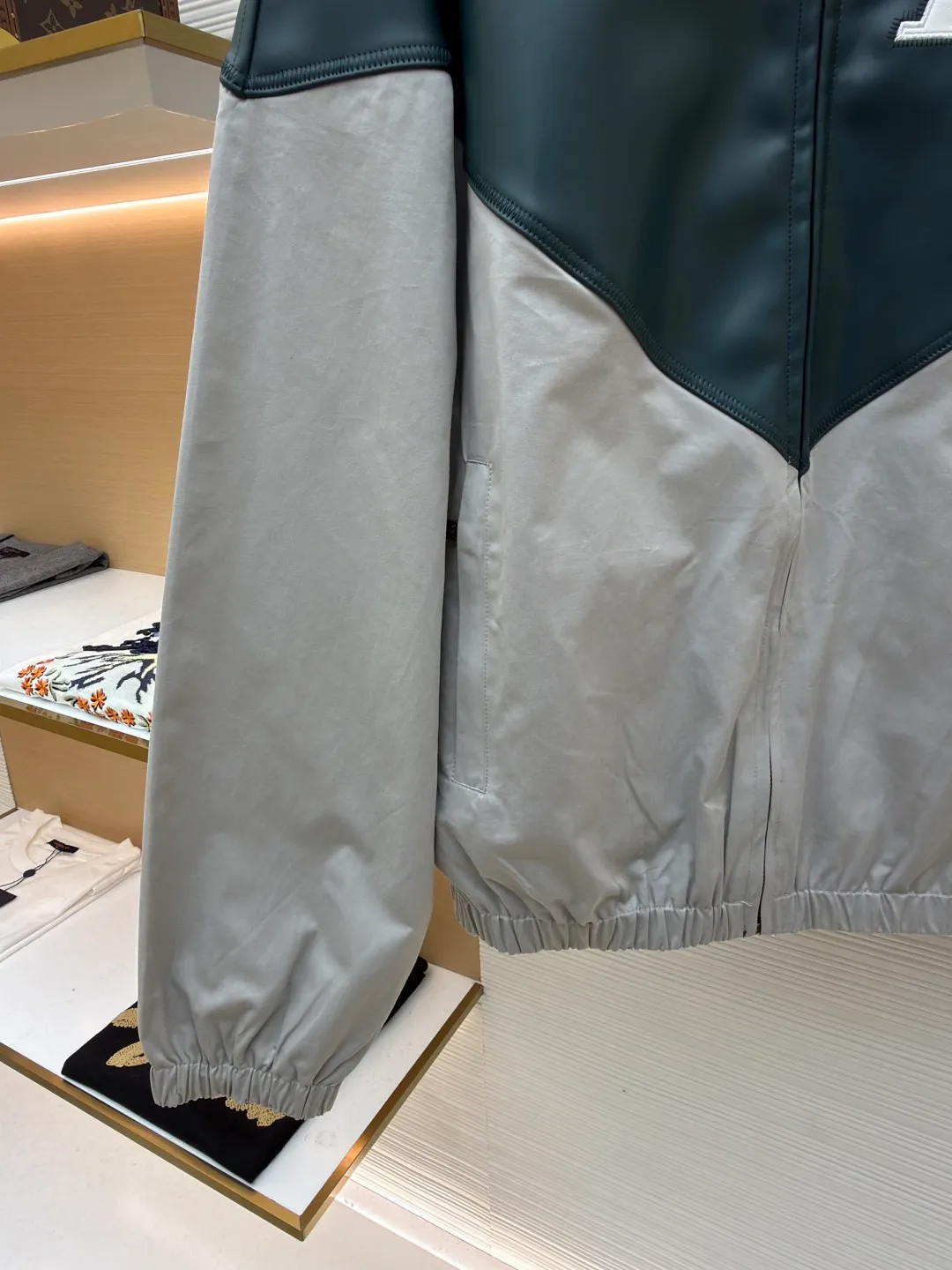 LOUIS VUITTON color-blocked sports long-sleeved jacket ●Original version: purchased and developed by 35590 ●Item number: 1681459-B80 ●Fabric: leather fabric ●Technology: intarsia production ●Color: gray-green splicing ●Version: fitted version ●Weight: about 800 grams ●Size: 46-48-50-52 ●Description: This jacket is made of high-quality genuine leather fabric. After special treatment, it feels soft and has a delicate luster. The contrasting color splicing design presents a fashionable layering. The stand-up collar structure is paired with a brand-customized metal zipper, and the zipper head is decorated with exquisite and luxurious pearls. The "LV" logo on the chest adopts three-dimensional leather embossing technology, with precise edge routing, strong three-dimensional effect and high recognition. The zipper pockets on both sides of the body are reinforced and sewn, which is practical and enhances the design. The splicing uses professional leather sewing technology, the stitch length is fine and even, and the ribbed design of the hem and cuffs fits the body shape. From the selection of genuine leather fabrics to the control of detailed craftsmanship, every process reflects LOUIS VUITTON's ultimate pursuit of craftsmanship precision and luxury style. It not only shows the high-end texture of leather items, but also highlights the brand design language through contrasting colors and three-dimensional logos. It is a fusion of leather craftsmanship and fashion design. The overall wiring is straight and delicate, the fabric is comfortable and soft, and the color is consistent without color difference. It can be matched with the same style to create a fashionable look and control various occasions. Customized accessories, complete with three standards, same style for men and women!